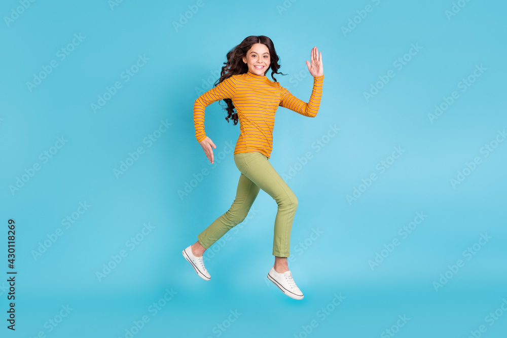 Full size profile photo of nice cheerful little lady rush fast beaming smile look camera isolated on blue color background Full size profile photo of nice cheerful little lady rush fast beaming smile look camera isolated on blue color background