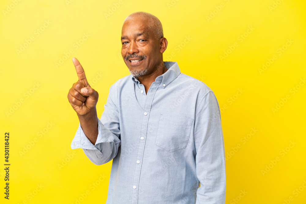 Cuban Senior isolated on yellow background showing and lifting a finger Cuban Senior isolated on yellow background showing and lifting a finger