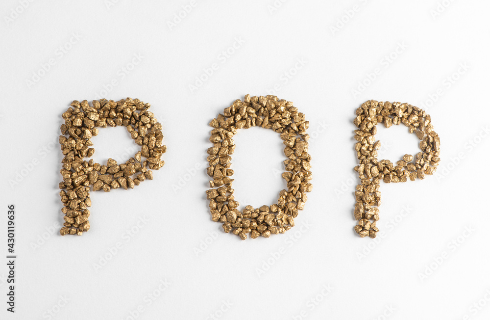 Top view on lettering POP made from golden nuggets on white background Top view on lettering POP made from golden nuggets on white background