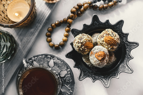 bowl with various pieces of Turkish delight locum and black tea with mint on a light background. Oriental sweets. Top view photo