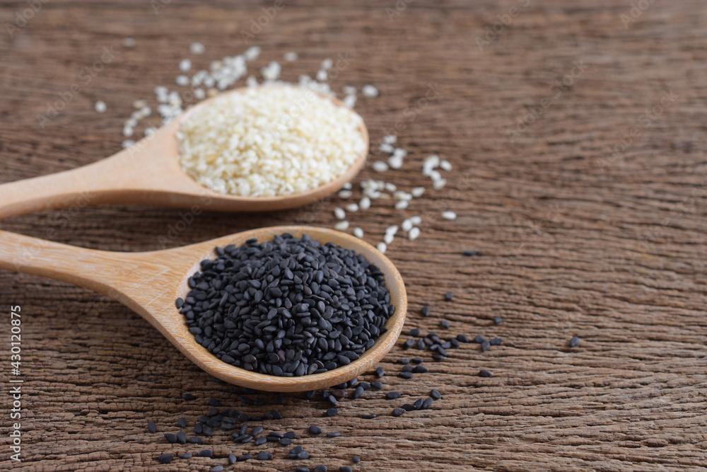Black (Poppy) and white sesame seeds in wooden spoon on wooden background,Copy space Black (Poppy) and white sesame seeds in wooden spoon on wooden background,Copy space