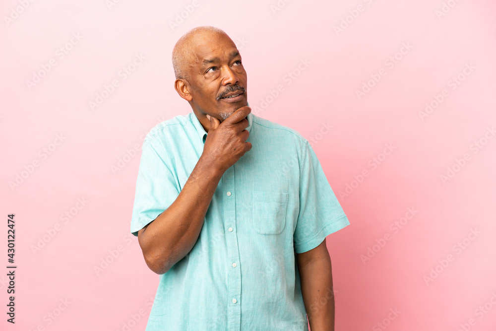 Cuban senior isolated on pink background and looking up