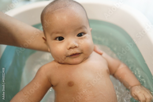Portrait of Happy Smiling Asian baby bathing in Bathtub.
