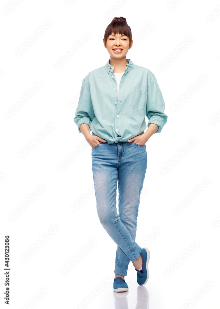 Fototapeta premium people, ethnicity and portrait concept - happy asian young woman in cotton shirt and jeans over white background
