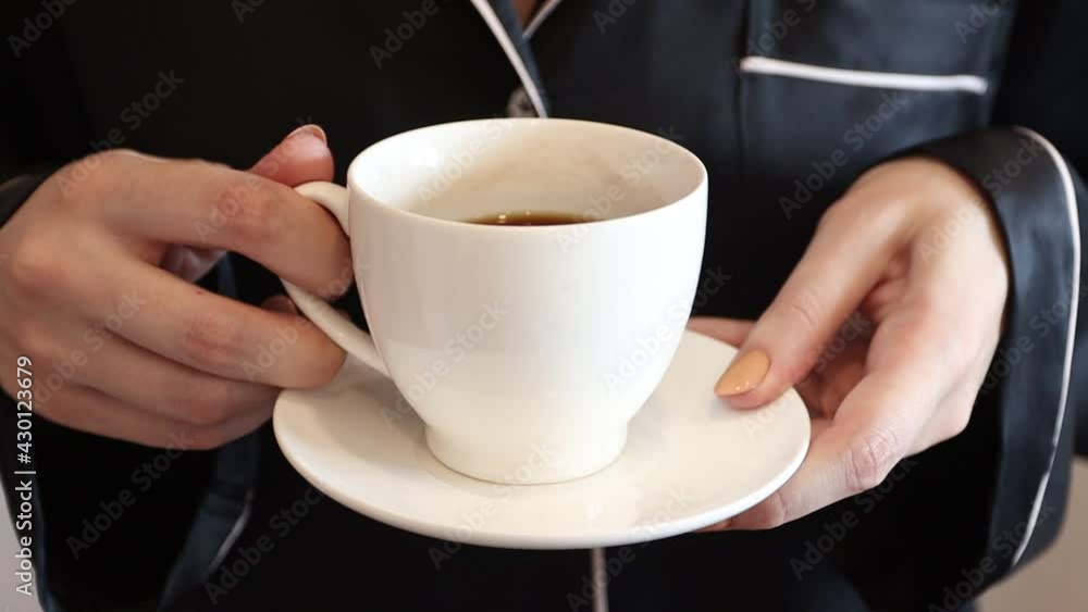 Young woman with a cup of coffee in her hands. Gitl holding a cup Young woman with a cup of coffee in her hands. Gitl holding a cup