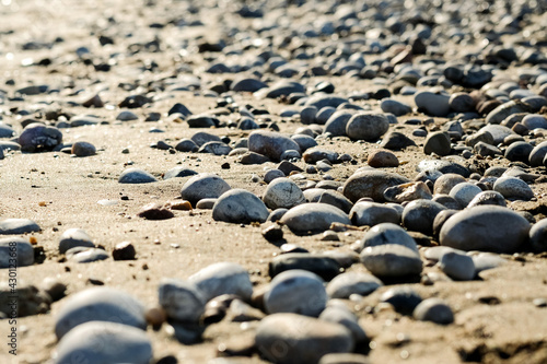 A close up view of smooth polished multicolored stones washed ashore on the beach. High quality photo