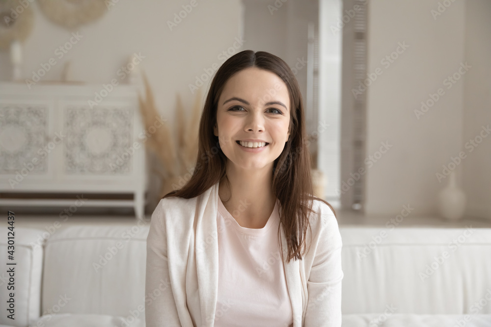 Video call screen view portrait of young millennial woman. Happy girl sitting on couch at home, looking at computer webcam, having job interview conversation, smiling and speaking at camera. Head shot Video call screen view portrait of young millennial woman. Happy girl sitting on couch at home, looking at computer webcam, having job interview conversation, smiling and speaking at camera. Head shot