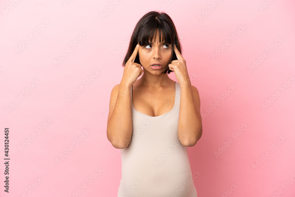 Young pregnant woman over isolated pink background having doubts and thinking Young pregnant woman over isolated pink background having doubts and thinking