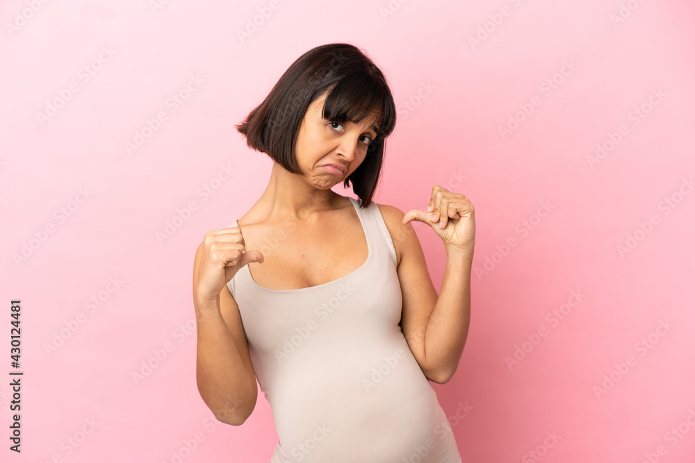 Young pregnant woman over isolated pink background proud and self-satisfied Young pregnant woman over isolated pink background proud and self-satisfied