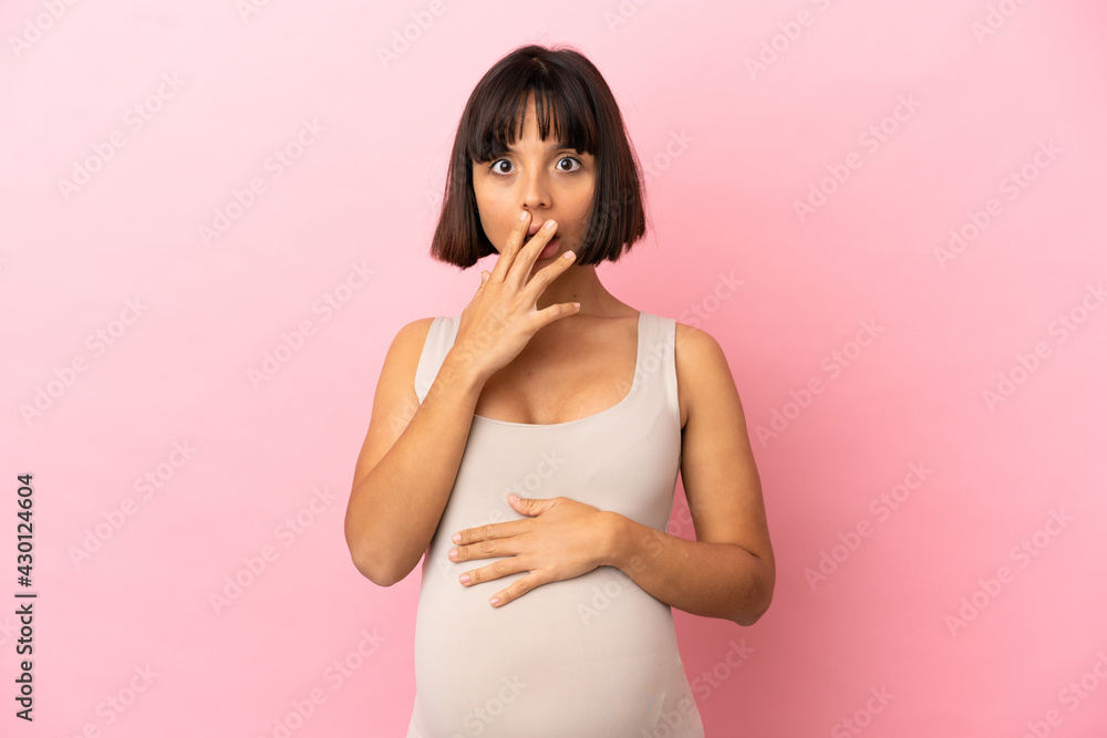 Young pregnant woman over isolated pink background surprised and shocked while looking right Young pregnant woman over isolated pink background surprised and shocked while looking right