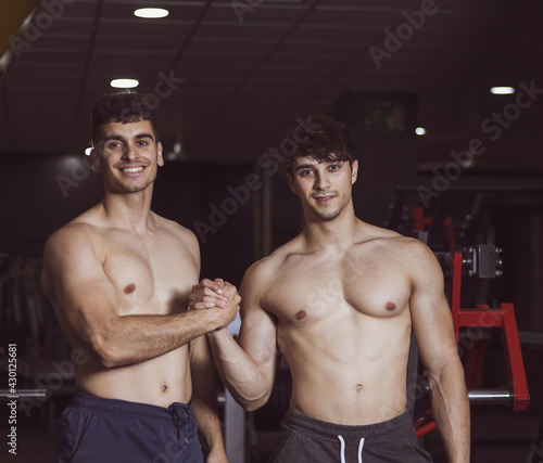 
two young athletes posing in a gym after doing sports