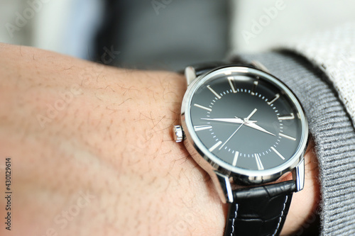 Businessman wearing luxury wrist watch with leather band, closeup