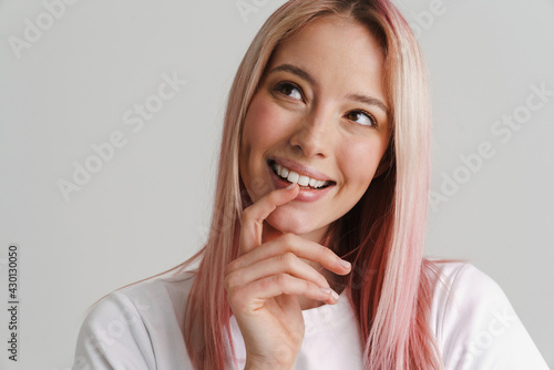 Young woman with pink hair smiling and looking aside