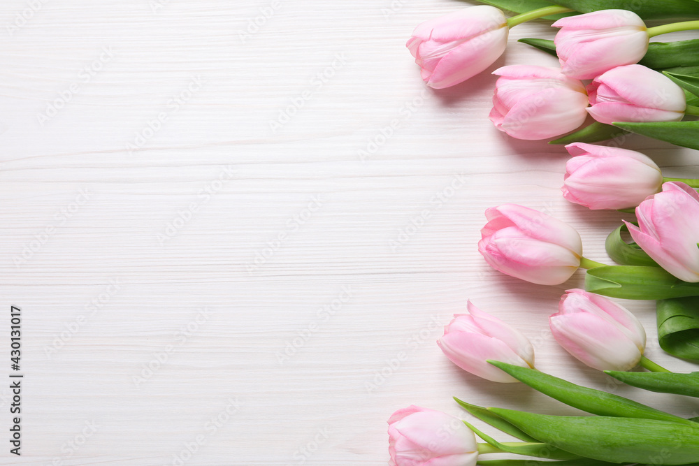 Beautiful pink spring tulips on white wooden background, flat lay. Space for text Beautiful pink spring tulips on white wooden background, flat lay. Space for text