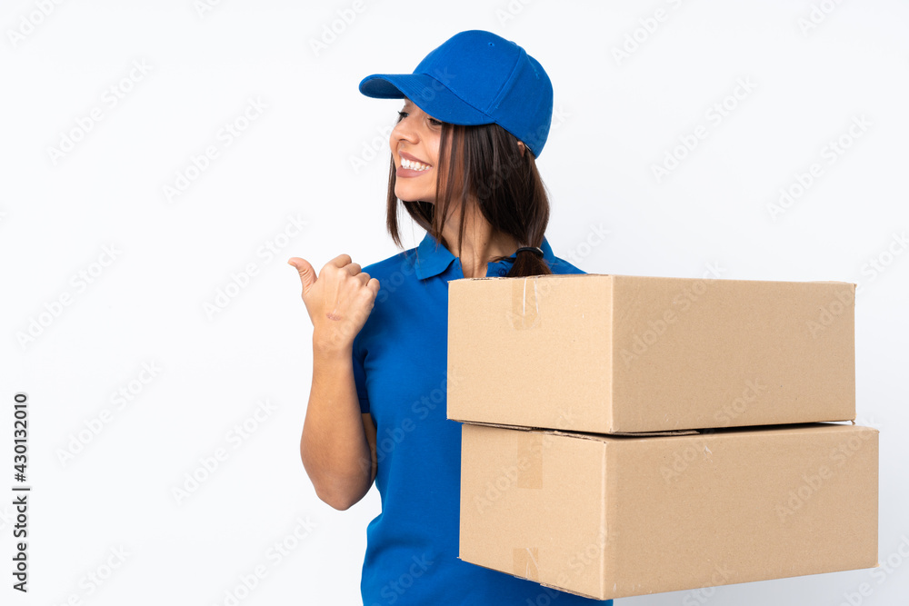 Young delivery brunette girl over isolated white background pointing to the side to present a product Young delivery brunette girl over isolated white background pointing to the side to present a product