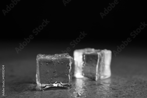 Ice cubes with water drops on grey stone table, closeup © New Africa