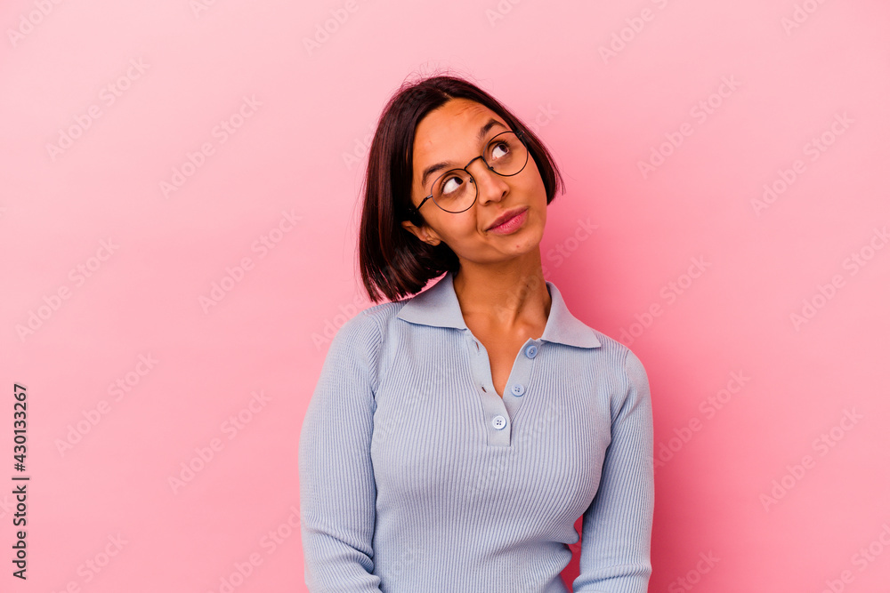 Young mixed race woman isolated on pink background relaxed and happy laughing, neck stretched showing teeth. Young mixed race woman isolated on pink background relaxed and happy laughing, neck stretched showing teeth.