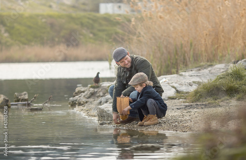 father and son let go of a homemade boat in the sea. The concept of mutual understanding and love of the father and son.