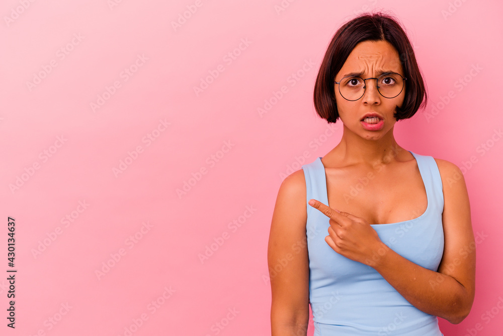 Young mixed race woman isolated on pink background pointing to the side Young mixed race woman isolated on pink background pointing to the side