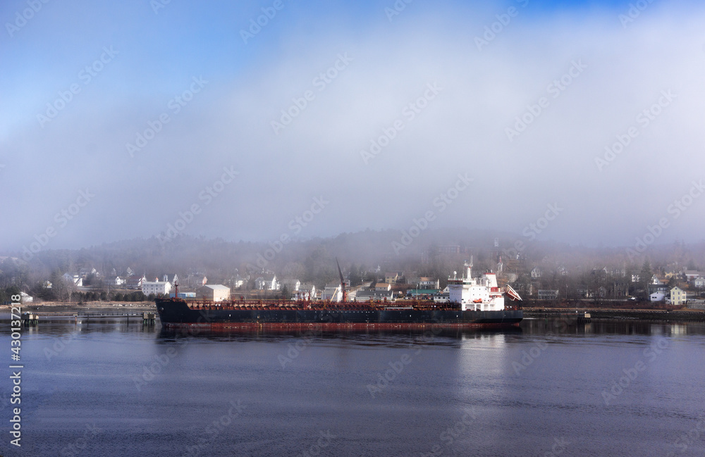 Large oil tanker at a commercial pier in Maine on a foggy day