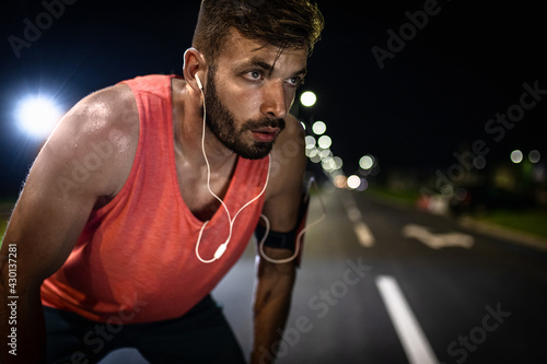 Man preparing to run through the city at night. © Zoran Zeremski