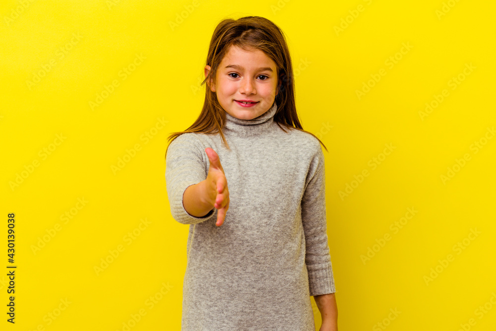 Little caucasian girl isolated on yellow background stretching hand at camera in greeting gesture. Little caucasian girl isolated on yellow background stretching hand at camera in greeting gesture.