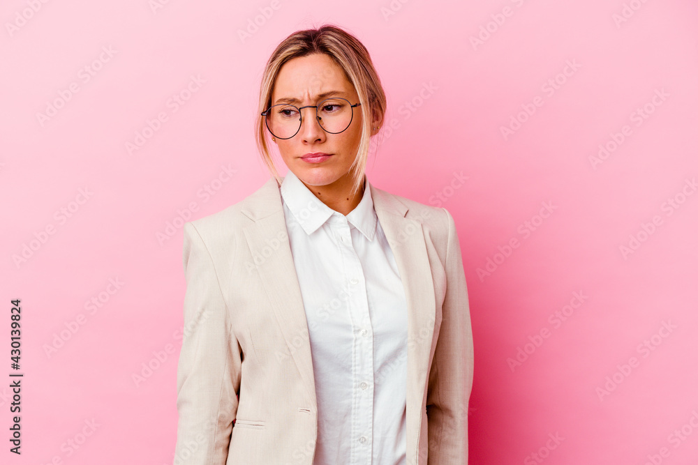 Young caucasian mixed race business woman isolated on pink background confused, feels doubtful and unsure. Young caucasian mixed race business woman isolated on pink background confused, feels doubtful and unsure.
