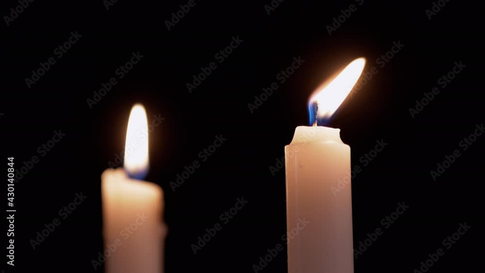 Two White Paraffin Candles Burn with Yellow Fire, on a Black Background. Wax candles with a bright moving flame, fire. Concept of memory, ritual, celebration. Church rites. 4K Two White Paraffin Candles Burn with Yellow Fire, on a Black Background. Wax candles with a bright moving flame, fire. Concept of memory, ritual, celebration. Church rites. 4K