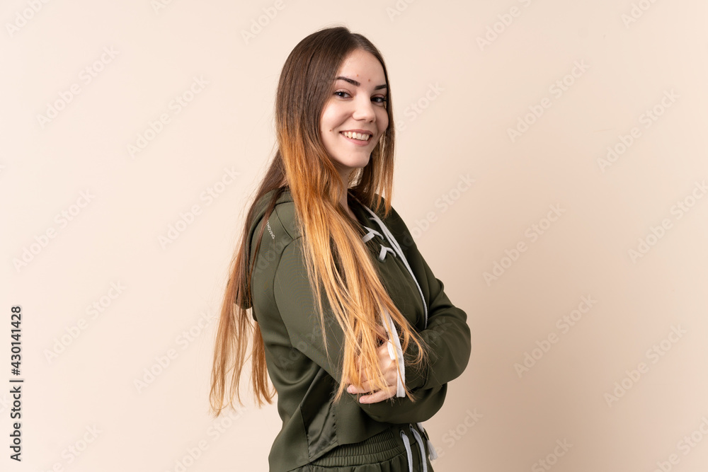 Young caucasian woman isolated on beige background with arms crossed and happy Young caucasian woman isolated on beige background with arms crossed and happy