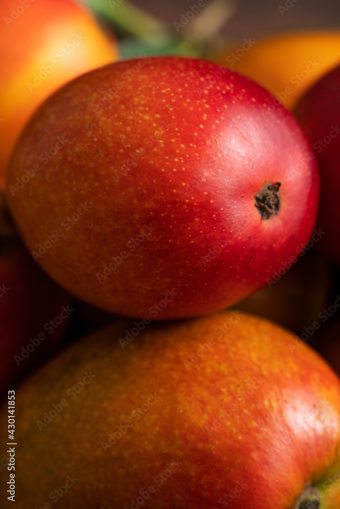 Mango. Fresh mango fruit on a bamboo sieve over dark wooden table background. Mango. Fresh mango fruit on a bamboo sieve over dark wooden table background.