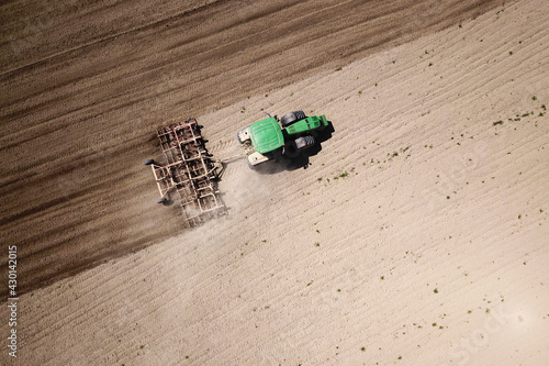 Принти на полотні Top view of Green Tractor cultivates the field with liner