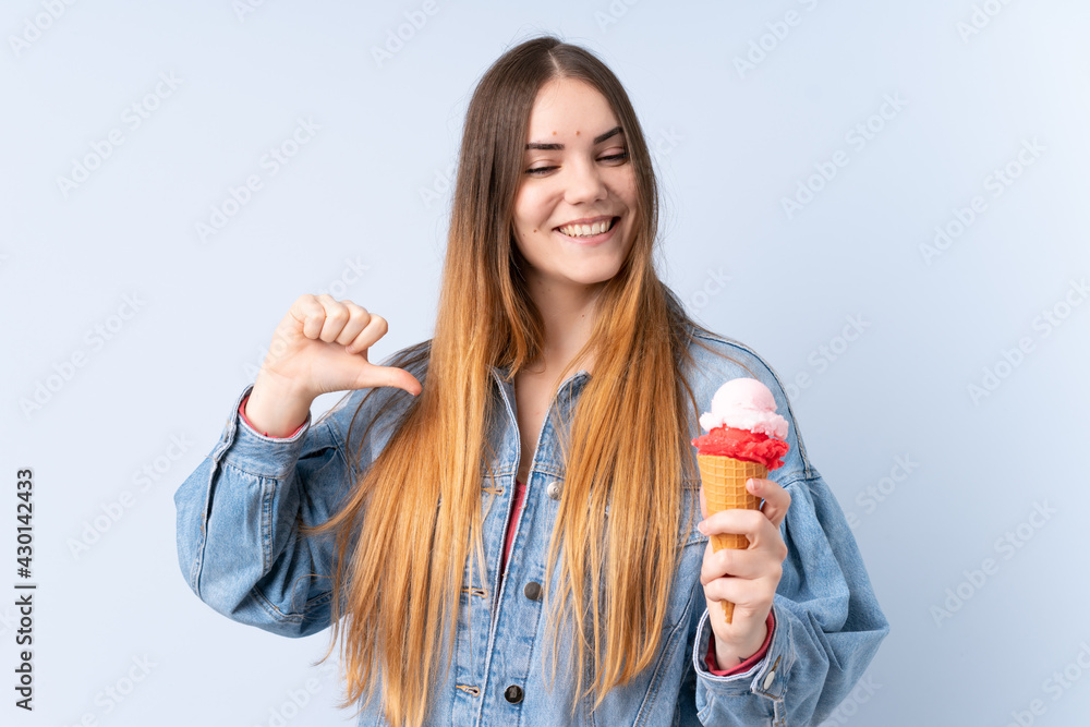 Young woman with a cornet ice cream isolated on blue background proud and self-satisfied Young woman with a cornet ice cream isolated on blue background proud and self-satisfied