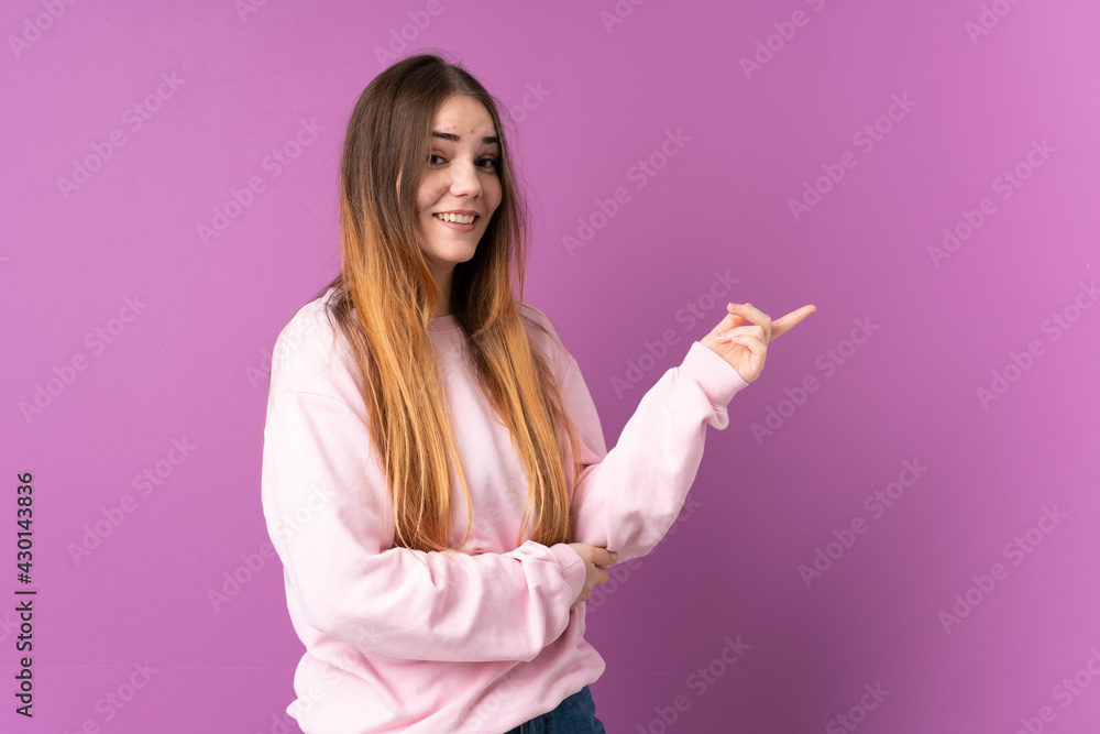Young caucasian woman isolated on purple background pointing finger to the side Young caucasian woman isolated on purple background pointing finger to the side