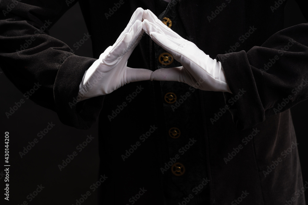 Hand gestures. Showman or magician illusionist in white gloves on a black background. Hand gestures. Showman or magician illusionist in white gloves on a black background.