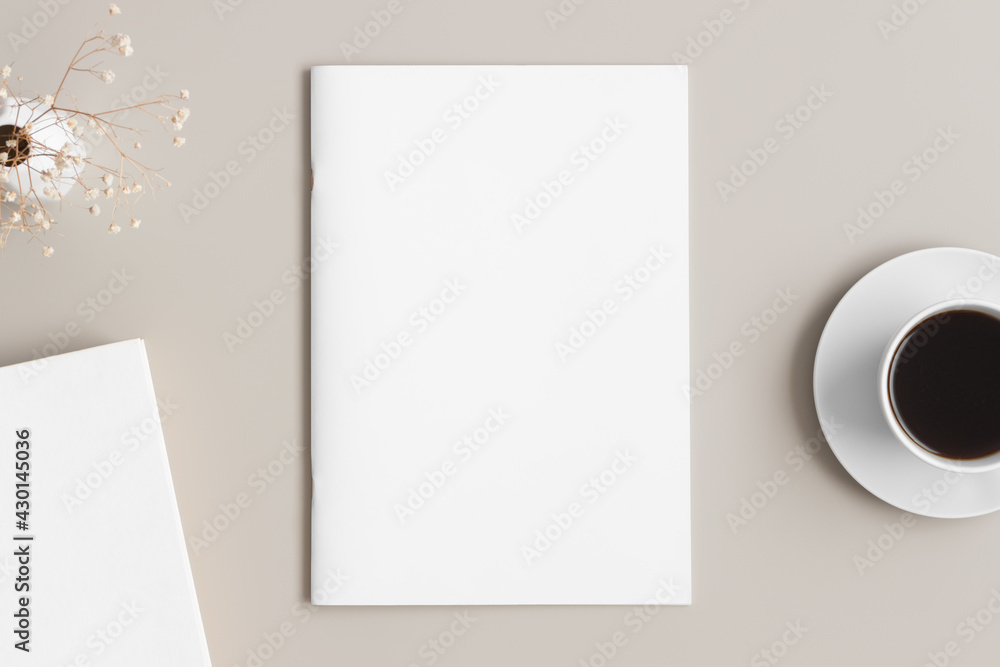 Magazine mockup with a cup of coffee, book and a gypsophila on the beige table. Magazine mockup with a cup of coffee, book and a gypsophila on the beige table.