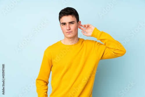 Teenager caucasian handsome man isolated on purple background having doubts © luismolinero