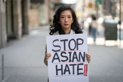 Wallpaper Mural Asian woman holding Stop Asian Hate sign protesting on a street in New York City Torontodigital.ca