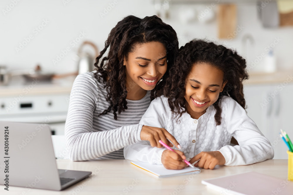 Beautiful black mother helping her daughter with homework Beautiful black mother helping her daughter with homework