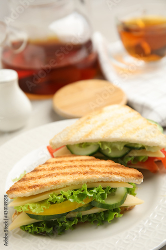Delicious sandwiches with vegetables and cheese on plate, closeup