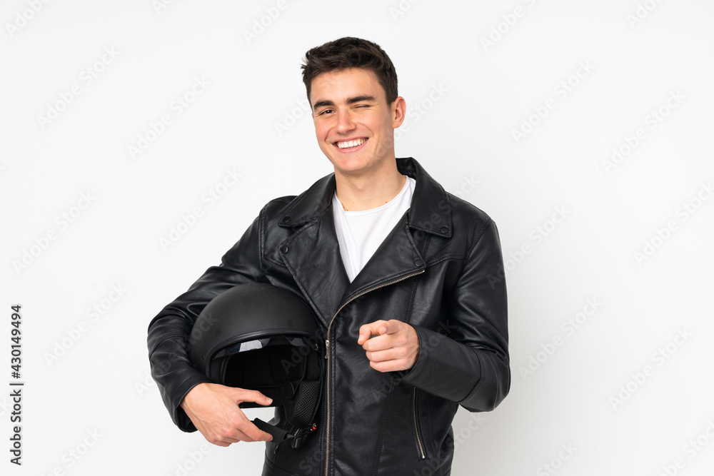 Man holding a motorcycle helmet isolated on white background points finger at you Man holding a motorcycle helmet isolated on white background points finger at you