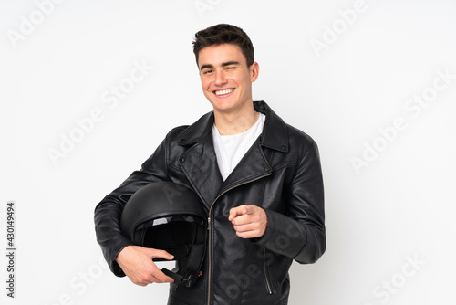 Man holding a motorcycle helmet isolated on white background points finger at you