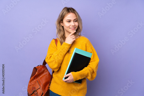 Teenager Russian student girl isolated on purple background looking to the side
