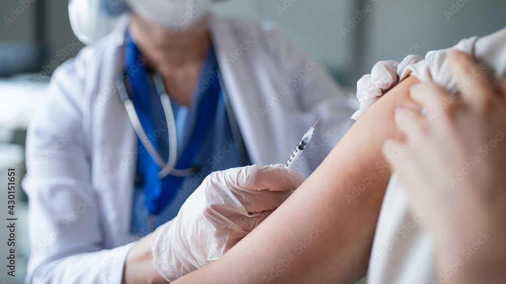 Unrecognizable woman getting vaccinated in hospital, coronavirus and vaccination concept. Unrecognizable woman getting vaccinated in hospital, coronavirus and vaccination concept.
