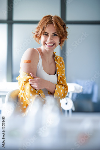 Cuadro en lienzo Happy woman with plaster on arm after vaccination in hospital, looking at camera