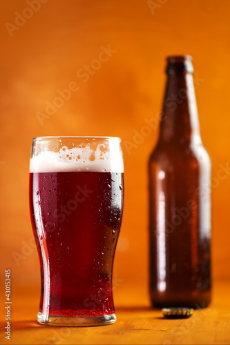 Cherry beer pint glass, summer cold berry low-alcohol radler drink. Wooden background