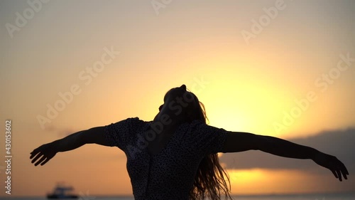 Carefree and happy woman dancing during sunset at the seascape. concept of healthy lifestyle and love of life