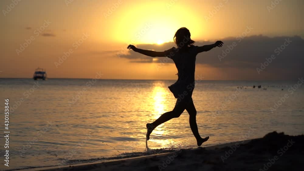 woman in dress running alone on the beach during sunset in slow motion. Concept enjoyment vacation an holiday woman in dress running alone on the beach during sunset in slow motion. Concept enjoyment vacation an holiday