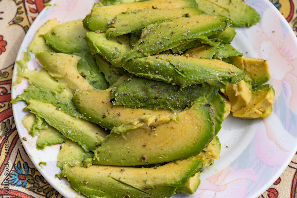 Sliced ripe avocado stocked top of the plate Sliced ripe avocado stocked top of the plate