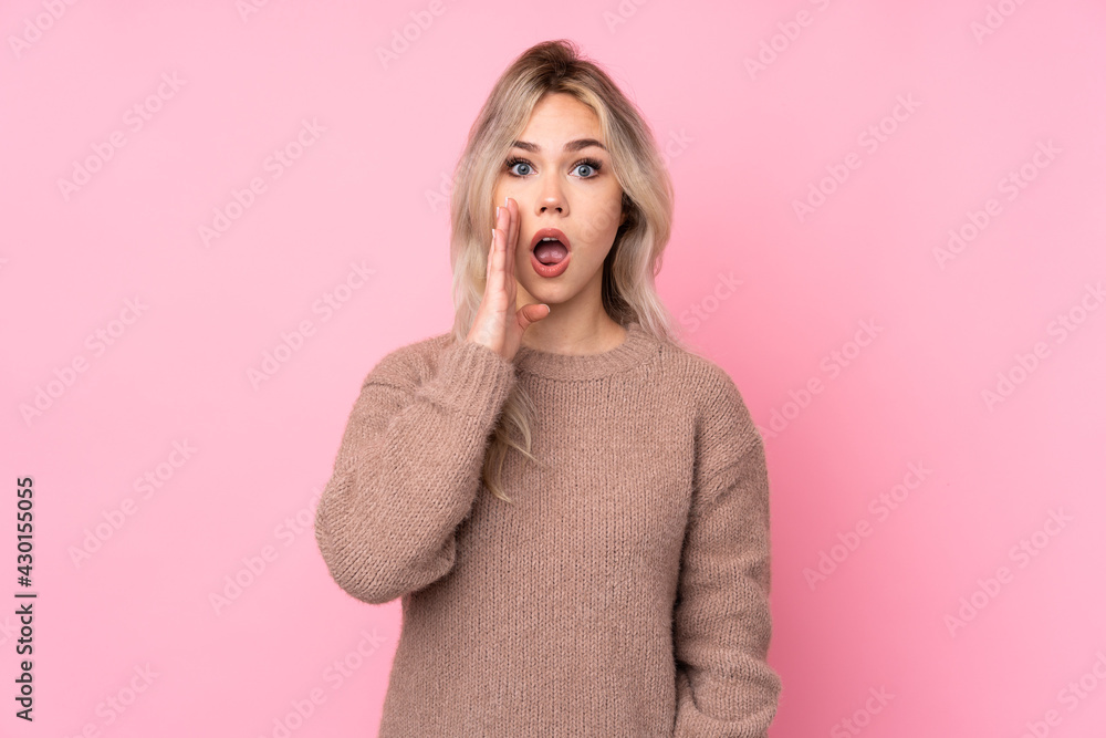 Teenager blonde girl wearing a sweater over isolated pink background with surprise and shocked facial expression Teenager blonde girl wearing a sweater over isolated pink background with surprise and shocked facial expression