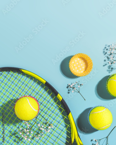 Tennis. Sunny summer sport composition with yellow tennis balls and racket on a blue background of hard tennis court with copy space. Sport and healthy lifestyle. The concept of outdoor game sports